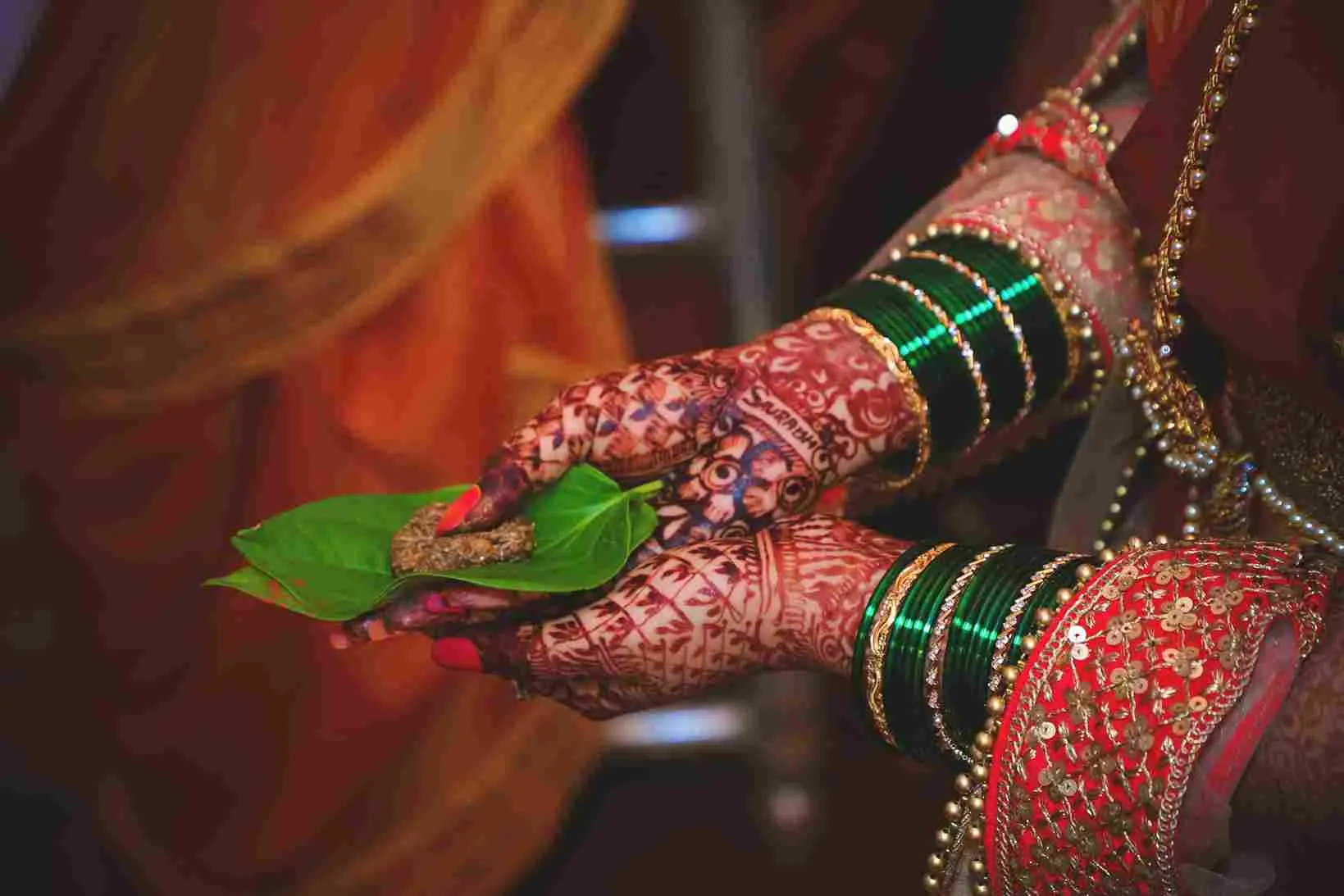 Close-up of a traditional South Indian bride’s hands adorned with green bangles and mehndi, beautifully coordinated by Tanmay Events — the best event management company in Thrissur for cultural and elegant weddings.